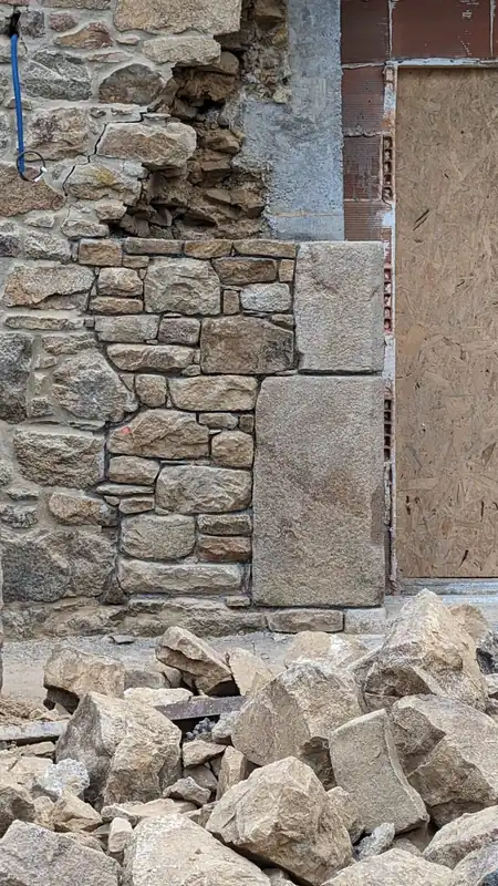Reprise d'un mur en pierre : pierres remontées une à une sur bâti ancien