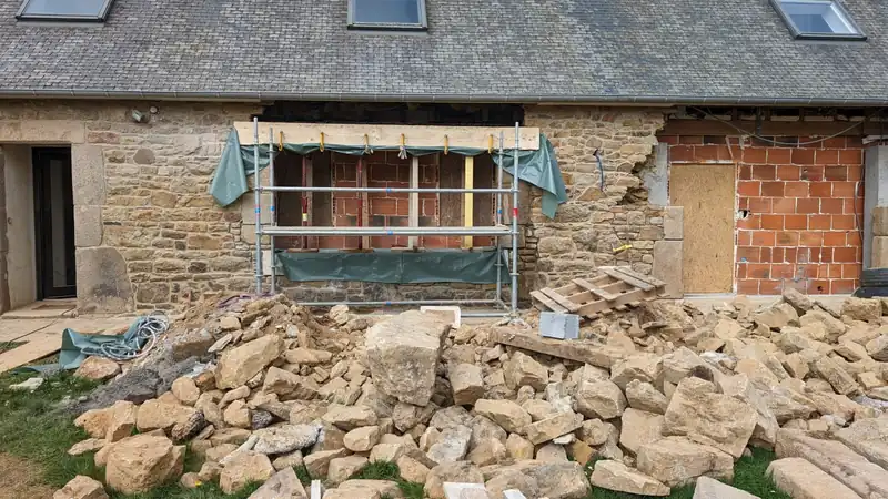 Reprise d'une ouverture en pierre sur mur ancien pendant le chantier